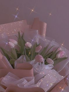 a bouquet of tulips and other flowers in a pink gift box with stars