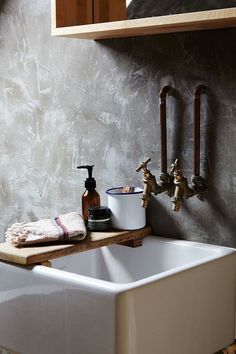 a white sink sitting next to a wooden shelf