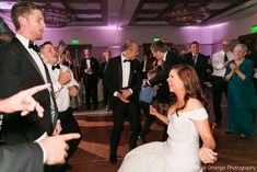 a bride and groom dancing on the dance floor at their wedding reception with guests in the background