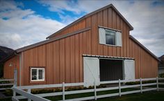 a barn with a white fence around it