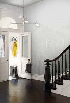 an entryway with wooden floors and white walls