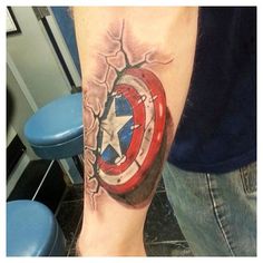 a man with a tattoo on his arm has a captain america shield