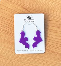 Unleash your inner nocturnal spirit with our Bat Earrings! These stunning earrings are designed to make a bold statement, featuring intricately detailed bats in a striking purple hue. Perfect for adding a touch of edgy elegance to any outfit, these earrings are lightweight and comfortable for all-day wear. Perfect for Halloween, themed parties, or everyday wear and a great gift for bat lovers or anyone who enjoys bold accessories. Click "Add to Cart" to get yours today and let your unique style Cheap Purple Halloween Earrings, Bat Wing Earrings, Cat Halloween Earrings, Gothic Nickel-free Halloween Earrings, Silver Spooky Halloween Earrings, Spooky Earrings, Acrylic Laser Cut, Edgy Elegance, Bat Earrings