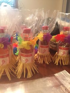 several bottles with colorful decorations on them sitting on a table next to some plastic bags