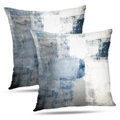 two blue and white pillows sitting next to each other