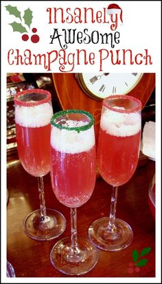 three wine glasses filled with liquid sitting on top of a table next to a clock