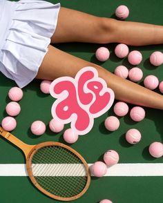 a tennis player's legs with pink balls and a sticker on the ground