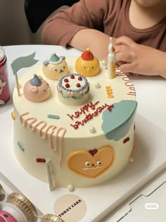 a child is sitting in front of a birthday cake