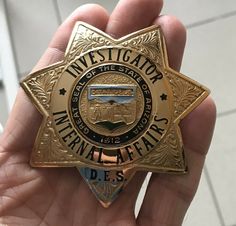 a person holding a police badge in their hand with the words investigater written on it