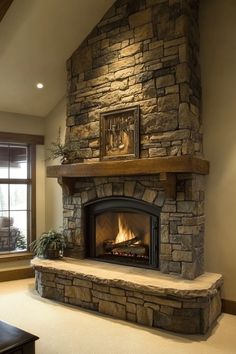 a living room with a stone fireplace and large windows