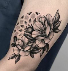 a black and white flower tattoo on the right arm, with an intricate design in the middle