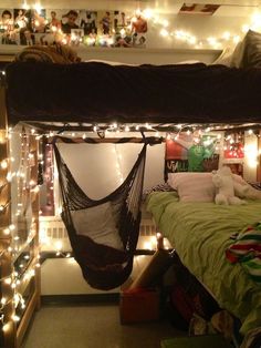 a hammock hangs from the ceiling above a bed in a dorm room with lights