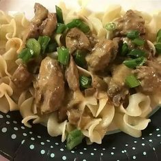 pasta with meat and green onions on a polka dot plate