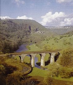 an old bridge over a river in the mountains