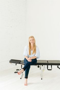 a woman sitting on top of a black bench