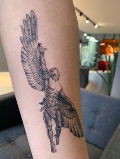 a tattoo on the leg of a woman with an angel holding a bird above her head