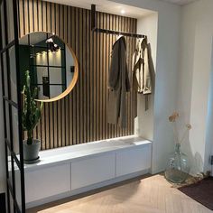 an image of a room with clothes hanging on the wall and a mirror above it