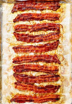 bacon strips are lined up on top of foil in a baking pan, ready to go into the oven