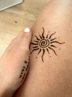 a woman's arm with a tattoo on it and the sun in the middle