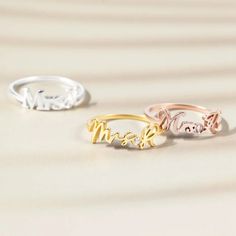 three personalized rings on top of each other with the word mom written in gold, silver and rose gold