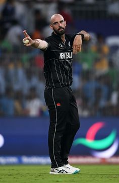 a man throwing a ball on top of a green field with his hand in the air