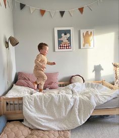 a small child jumping on top of a bed