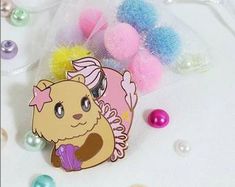 a little pony brooch sitting on top of a table next to some balls and beads