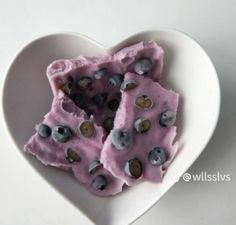 a heart shaped bowl filled with food on top of a table