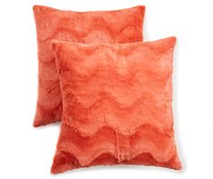 two orange pillows sitting next to each other