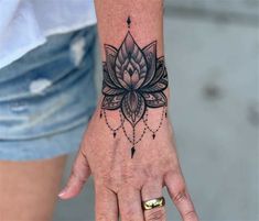 a woman's hand with a flower tattoo on it