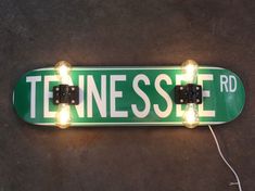 a green and white street sign with some lights on it's sides that says tennessee rd