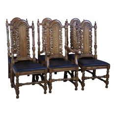 four wooden chairs with black leather seats on each side and one has an intricate carved back