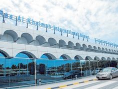 cars are parked in front of a building with arches on the roof and windows,