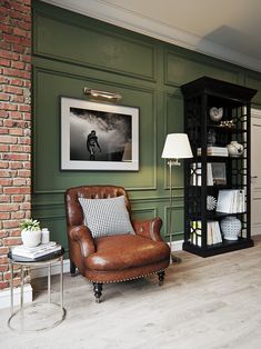 a living room filled with furniture and a tall book case next to a lamp on a table