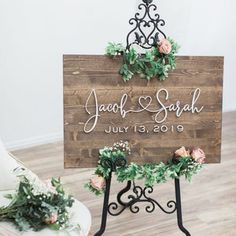 a wooden sign with greenery and flowers on it that says,'jacof & sarah july 19, 2019 '