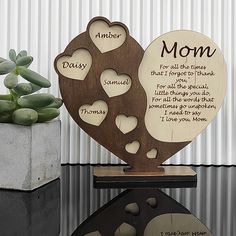 two heart shaped wooden plaques sitting on top of a table next to a succulent plant