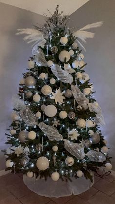 a white christmas tree with angel wings and ornaments