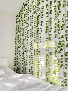 a bed sitting under a window covered in green ivy leaves on the side of it