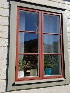 two potted plants are sitting in the window sill