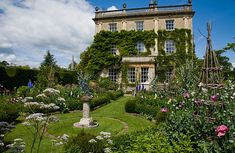 a large house with lots of flowers around it