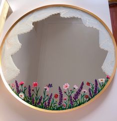 a mirror that has flowers painted on it