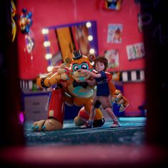 two children are hugging in front of a cartoon character that appears to be an orange cat