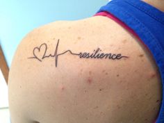 the back of a woman's shoulder with a heartbeat tattoo that reads, resilince