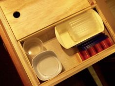 an open drawer with bowls and plates in it