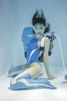 a woman in scuba gear sitting on the ground