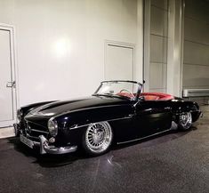 an old black car parked in front of a building