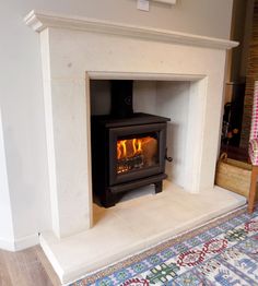 a fireplace with a wood burning stove inside of it on top of a carpeted floor