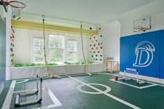 an indoor basketball court with swings and balls on the floor in front of a window