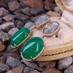 These dazzling two-section dangle earrings each feature one (1) prong set oval cabochon cut natural dyed green quartz cabochon that is bordered with thirty-six (36) prong set round brilliant cut diamonds. Atop each earring is one (1) prong set oval cabochon cut natural moonstone that is bordered with thirty (30) prong set round brilliant cut diamonds. The earrings measure 42.0mm X 17.4mm and are finished with friction backs. Luxury Oval Cabochon Earrings For Anniversary, Elegant Green Cabochons As Gifts, Elegant Green Cabochons For Gifts, Fine Jewelry Oval Cabochon Earrings, Luxury Oval Gemstone Earrings, Luxury Green Oval Earrings, Luxury Cabochon Drop Earrings, Elegant Oval Cabochon Jade Jewelry, Elegant Green Cabochon Earrings