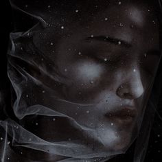 a woman's face is covered with veils and snowflakes as she stares into the distance